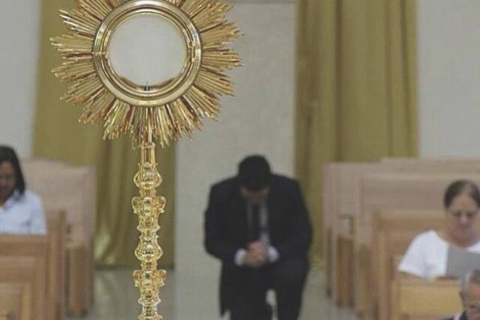 Hombre arrodillado ante el Santísimo Sacramento.